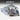 Motherboard auction: A bare server motherboard with a large silver heatsink and port covers, shown next to its desiccated storage bag on a white surface. The brand 'auction-it' is visible at the top of the image.